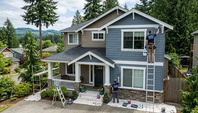 Professional house painters in Redmond WA applying exterior paint to a modern home façade
